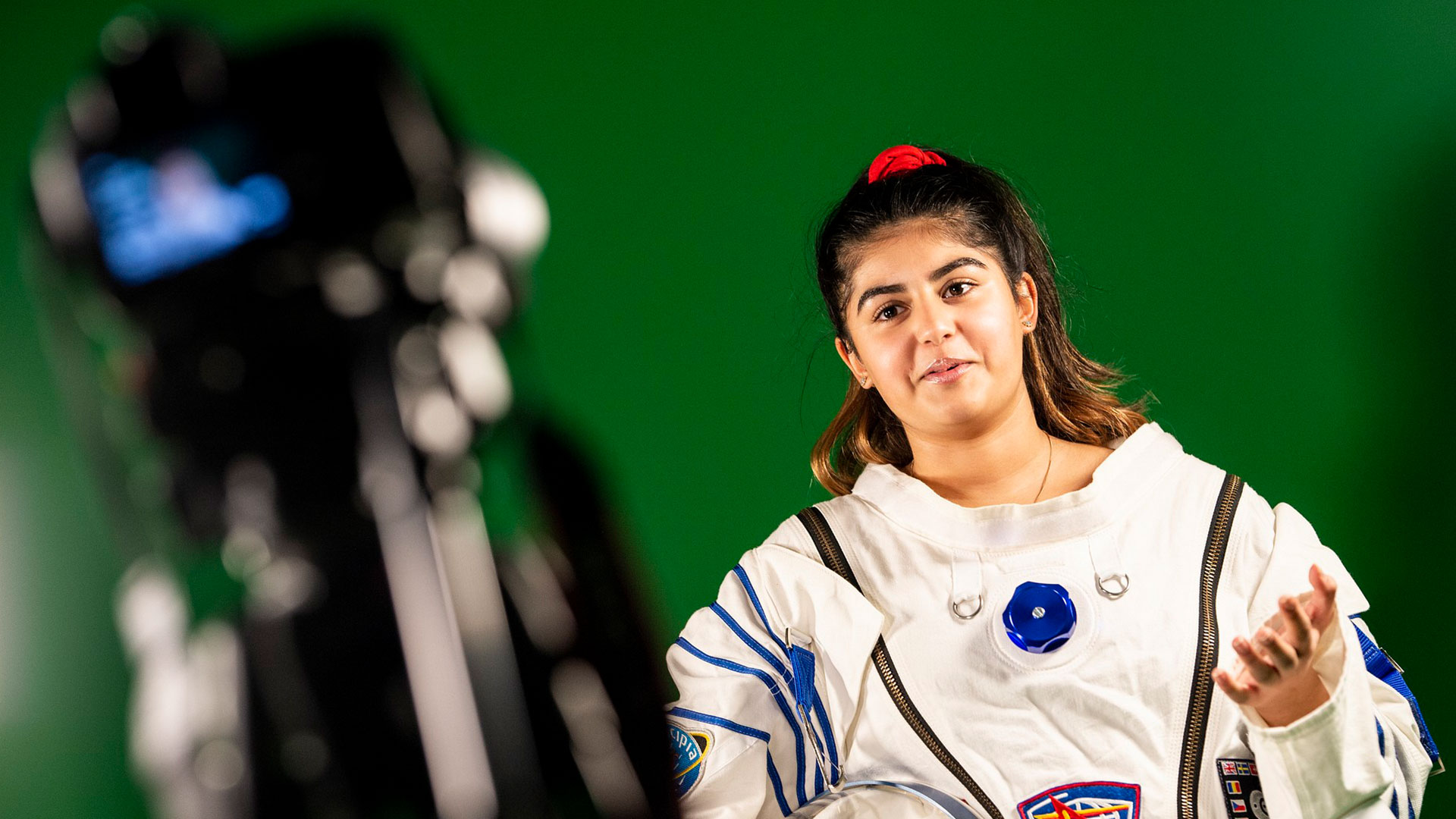 Young girl in an astronaut costume on the green screen in the Immersive Academy