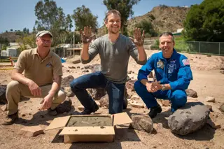 Matt Damon making cement hand prints on his visit to the Mars yard of NASA's Jet Propulsion Laboratory.