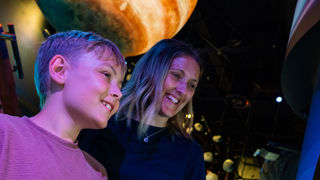 Mother and son enjoy an interactive challenge in the Solar System gallery