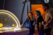 Group of adults interacting with the orrery