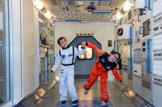 Two children dressed as astronauts in Columbus Module