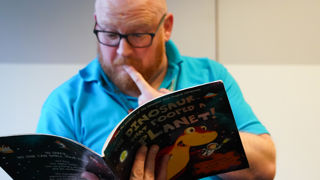 Education team member reads a story at Small Space day