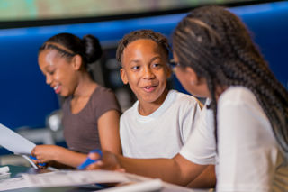 Three happy children making paper rockets in Home Planet gallery