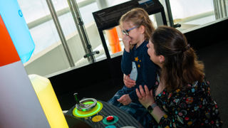 Mother and child laughing in Britain's Space Race gallery in the Rocket Tower