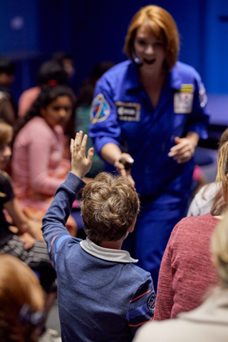 Education Facilitator talking with a child as part of a LIVE Space presentation