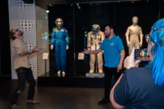 Adults participating in a science busk in the Welcome Hall