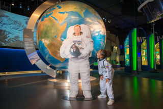Child in a spacesuit with Tim Peake