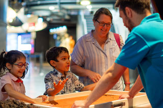 Family with an Education Facilitator participating in a hands on science busk