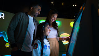 Family engaging with an interactive display in the Home Planets gallery