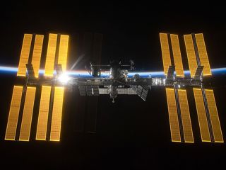 A photo of the International Space Station with a backdrop of space and the thin blue line of Earth's atmosphere.