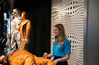 Education Facilitator with a high altitude spacesuit offering a hands on science busk