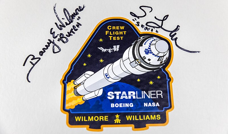  The signatures of NASA astronauts Barry Wilmore and Sunita Williams are photographed alongside NASA’s Boeing Crew Flight Test mission insignia.