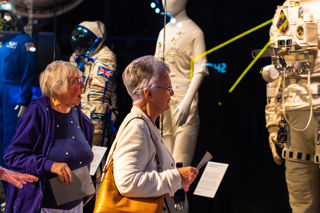 Two older ladies looking at the spacesuit display in the welcome hall